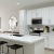 a kitchen with white cabinets with nearby dining